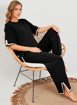 Loungewear femme noir élégant assise sur fauteuil