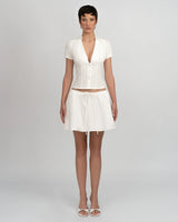 Ensemble blanc femme composé d’un top à col plongeant et jupe courte