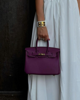 Sac violet porté à la main avec robe blanche – look citadin féminin