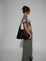 Look urbain avec sac noir, femme debout en silhouette