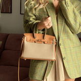 Sac Élise porté à la main avec manteau vert – contraste chic et moderne